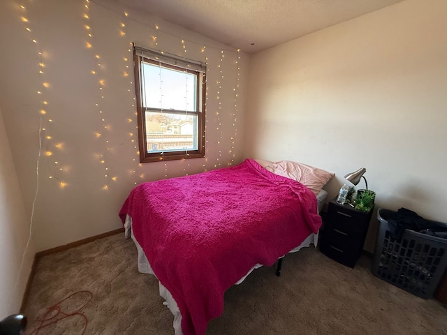 bedroom with carpet, baseboards, and a textured ceiling