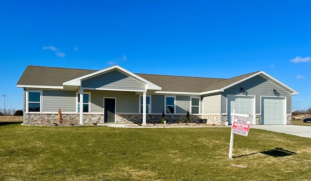 view of front facade featuring a front lawn, covered porch, and a garage