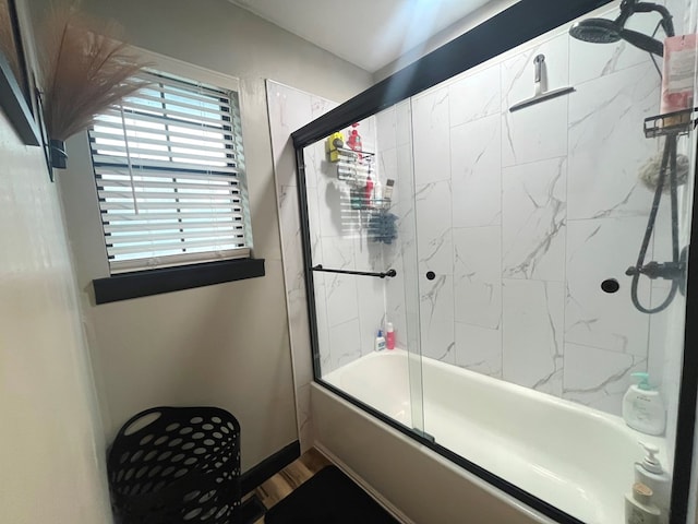 bathroom with bath / shower combo with glass door