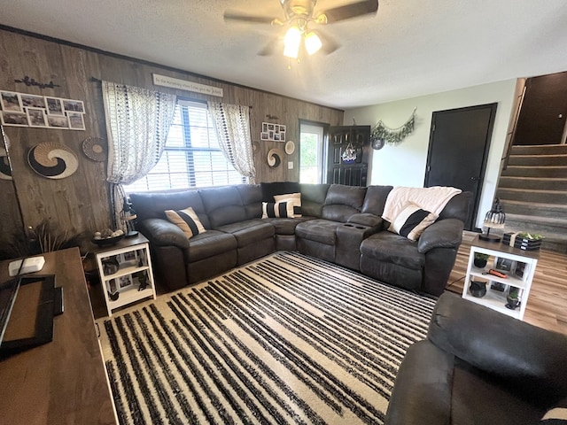 639 Missouri Ave, Chillicothe, MO 64601 - living area with wooden walls, ceiling fan, stairs, and a textured ceiling