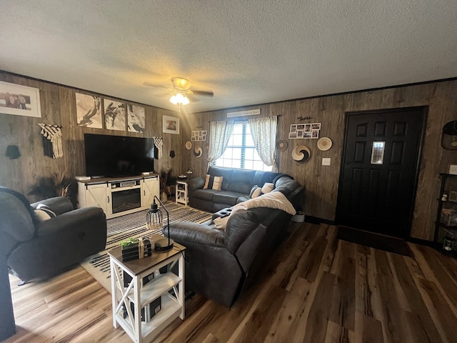 639 Missouri Ave, Chillicothe, MO 64601 - living area with wooden walls, wood finished floors, a textured ceiling, and ceiling fan