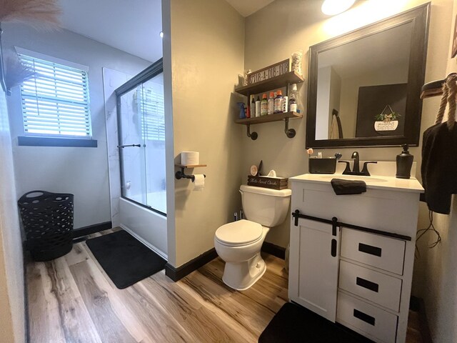 639 Missouri Ave, Chillicothe, MO 64601 - full bathroom featuring wood finished floors, vanity, and bath / shower combo with glass door