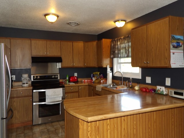 kitchen featuring a textured ceiling, kitchen peninsula, sink, and appliances with stainless steel finishes