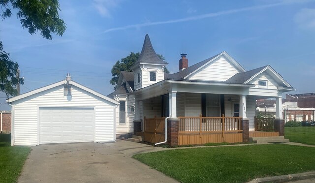 418 Elm St, Chillicothe, MO 64601 - view of front facade with a porch, an outdoor structure, driveway, a front lawn, and a detached garage