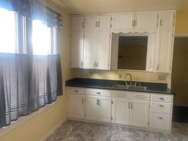 418 Elm St, Chillicothe, MO 64601 - kitchen with a sink, dark countertops, and white cabinets
