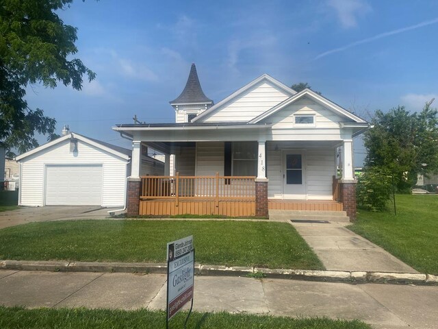 418 Elm St, Chillicothe, MO 64601 - view of front of house featuring a porch, a front lawn, an outbuilding, a detached garage, and driveway