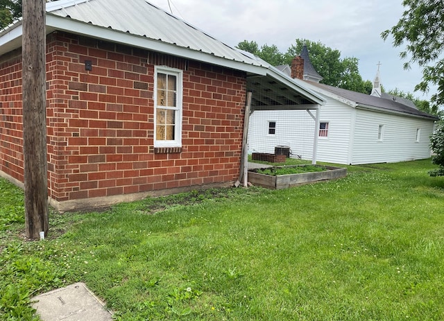 418 Elm St, Chillicothe, MO 64601 - view of side of home with a lawn, brick siding, metal roof, central AC, and a garden