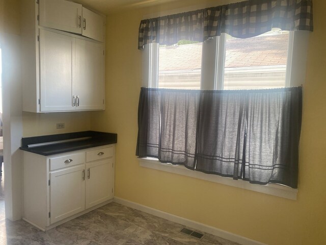 418 Elm St, Chillicothe, MO 64601 - kitchen with dark countertops, baseboards, and white cabinets