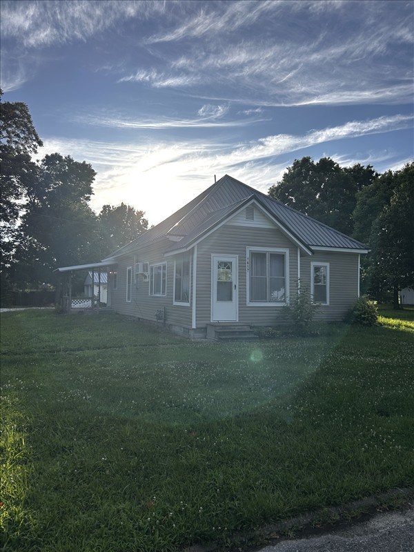 1617 N Church St, Marceline, MO 64658 - view of front of home featuring a front lawn, entry steps, and a metal roof