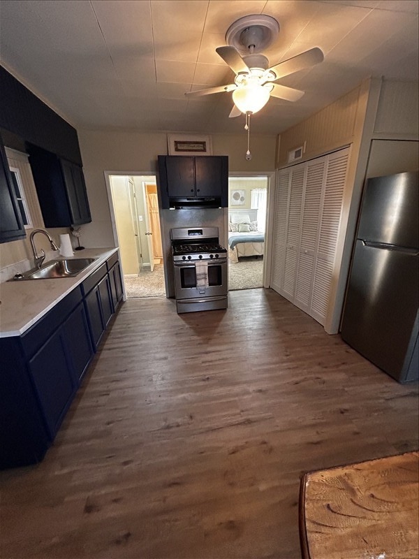 1617 N Church St, Marceline, MO 64658 - kitchen featuring stainless steel appliances, dark wood finished floors, light countertops, ceiling fan, and range hood