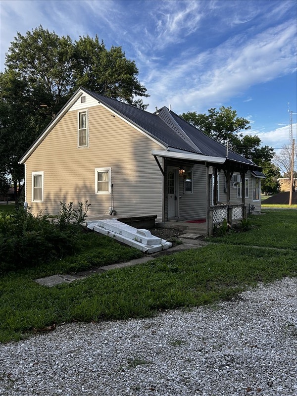 1617 N Church St, Marceline, MO 64658 - view of home's exterior featuring a metal roof and covered porch
