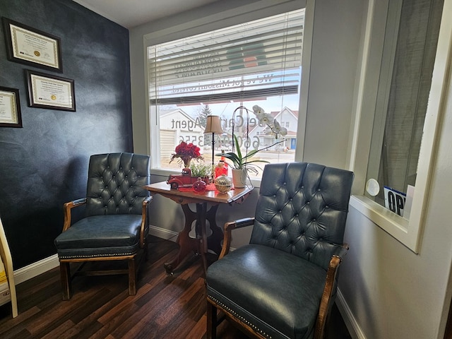 living area featuring baseboards and wood finished floors