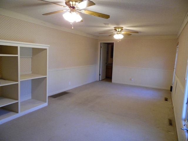 carpeted spare room featuring ceiling fan and ornamental molding