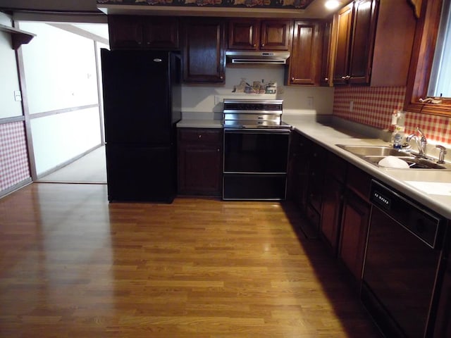 kitchen featuring sink, light hardwood / wood-style floors, and black appliances