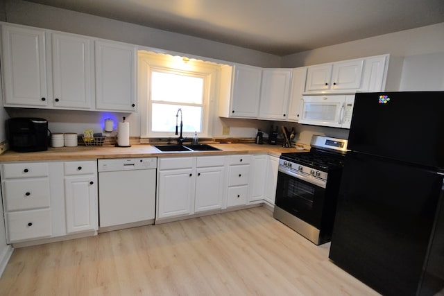 kitchen featuring sink, white cabinets, white appliances, and light wood-type flooring