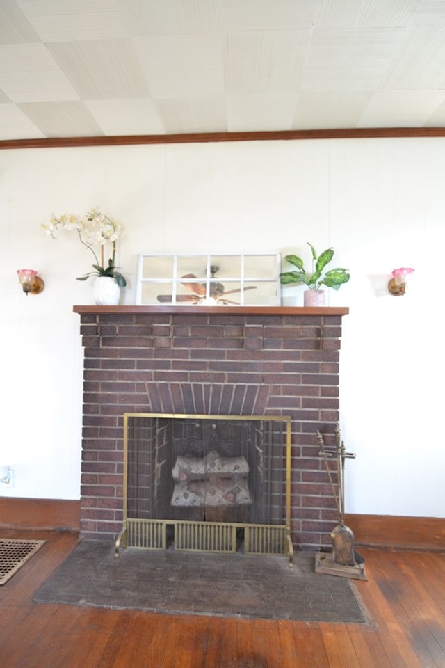 interior details with wood-type flooring and a brick fireplace