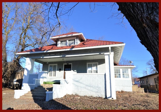 bungalow-style house featuring covered porch and metal roof