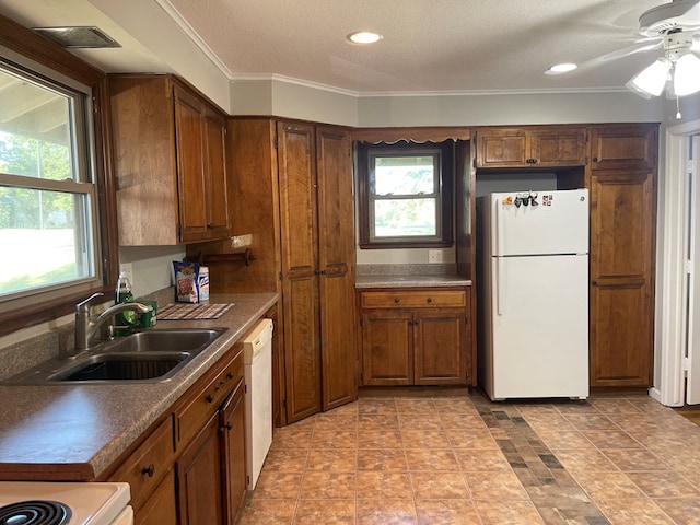 kitchen with a textured ceiling, ceiling fan, white appliances, and sink