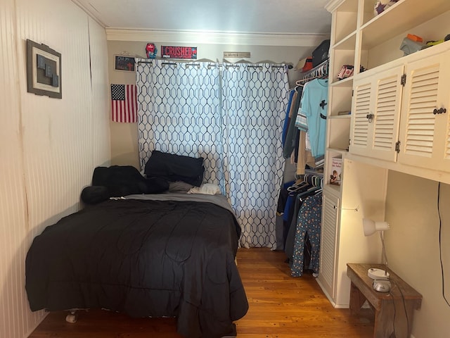 bedroom with hardwood / wood-style floors and crown molding