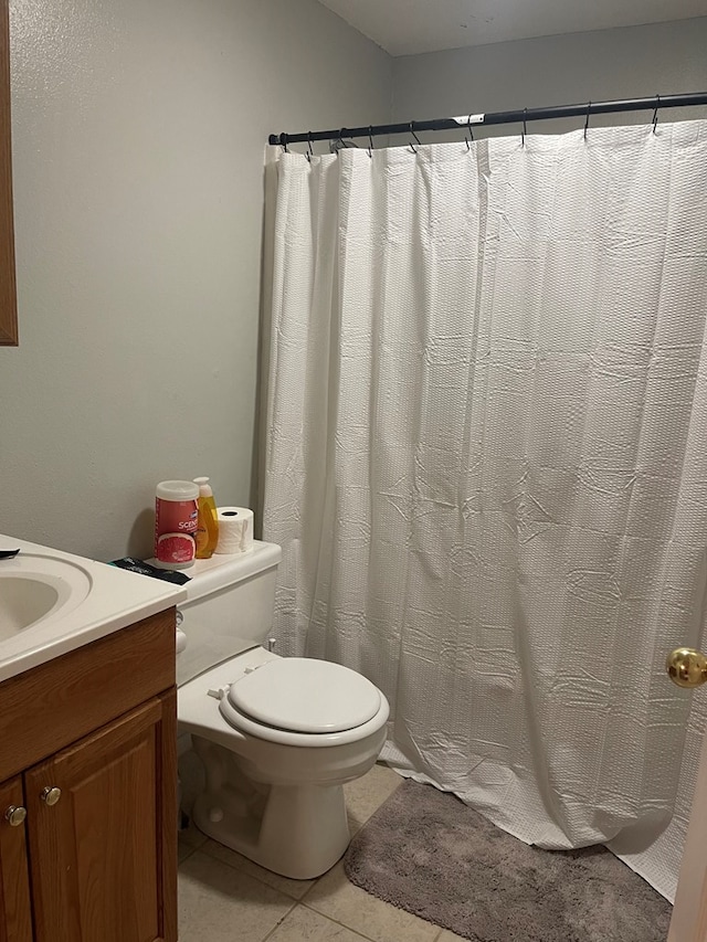 bathroom featuring tile patterned flooring, vanity, and toilet