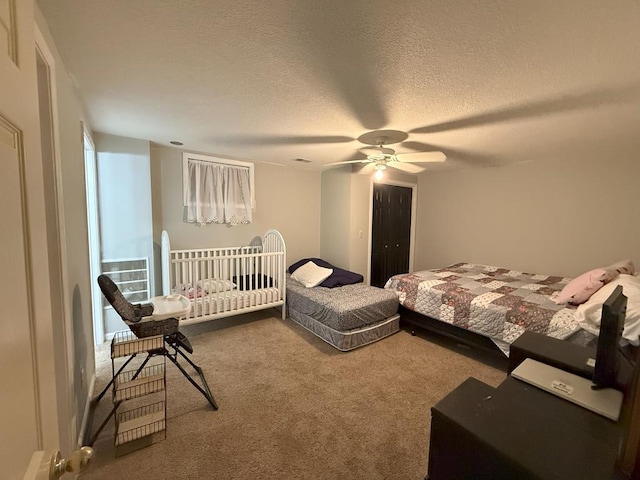 carpeted bedroom with ceiling fan and a textured ceiling