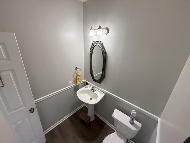 bathroom with baseboards, toilet, and wood finished floors