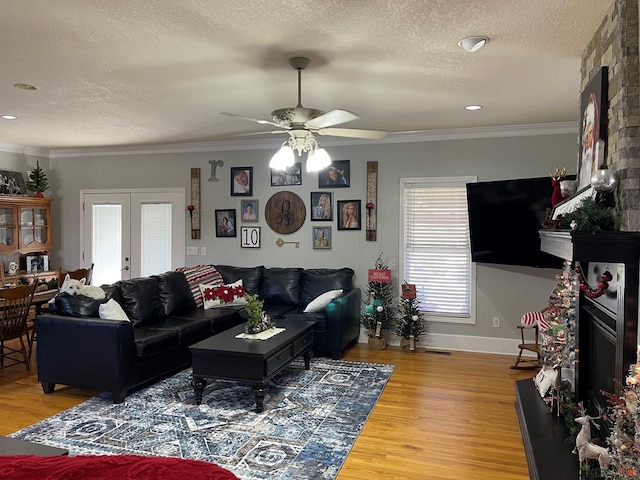 living room with crown molding, french doors, ceiling fan, and a textured ceiling