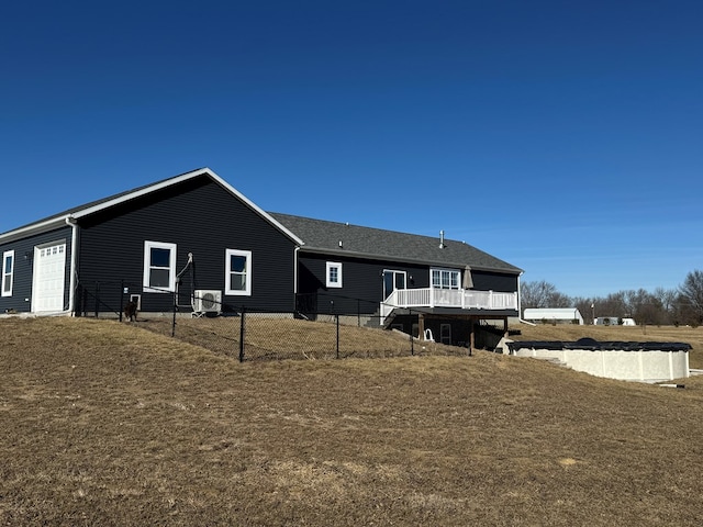 rear view of house with a wooden deck and a lawn