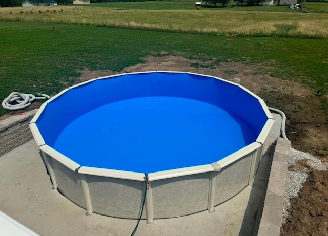 view of pool featuring a lawn