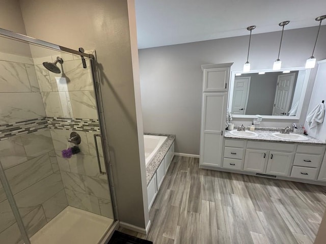 bathroom featuring plus walk in shower, hardwood / wood-style floors, and vanity