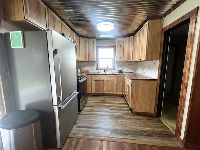 115 Polk St, Chillicothe, MO 64601 - kitchen featuring appliances with stainless steel finishes, light brown cabinets, wood finished floors, and decorative backsplash