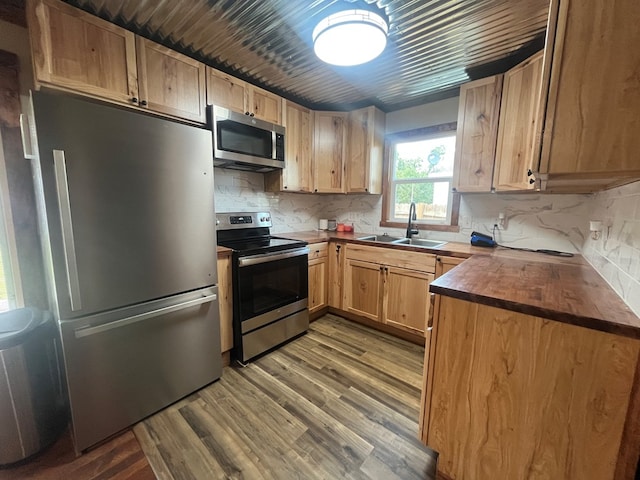 115 Polk St, Chillicothe, MO 64601 - kitchen featuring stainless steel appliances, wood finished floors, backsplash, and light brown cabinetry