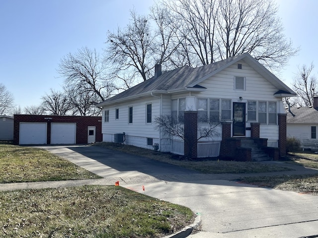 view of front of home with an outbuilding, cooling unit, driveway, and a chimney