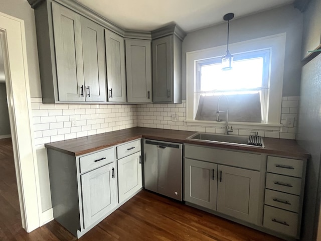 kitchen with dishwasher, butcher block counters, dark wood-type flooring, and a sink