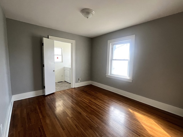 spare room with plenty of natural light, baseboards, and wood finished floors