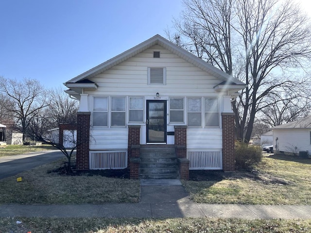 bungalow-style house with brick siding and entry steps