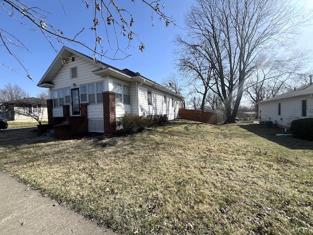 view of home's exterior with brick siding and a lawn