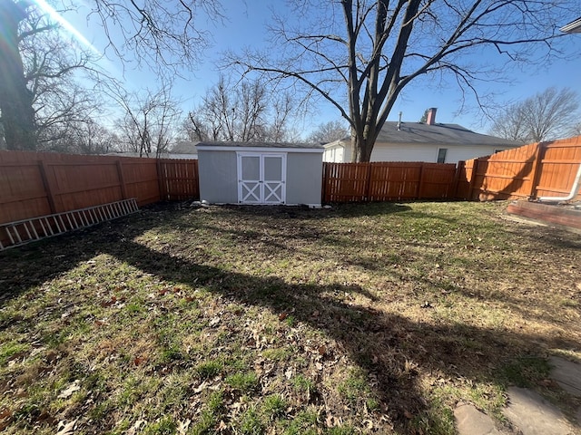 view of yard featuring an outdoor structure, a fenced backyard, and a shed