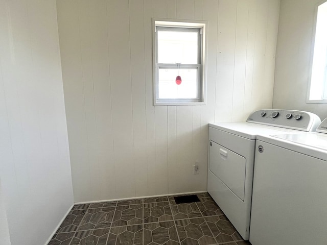 clothes washing area with laundry area, plenty of natural light, and separate washer and dryer