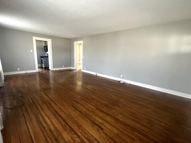 unfurnished room with baseboards and dark wood-style flooring