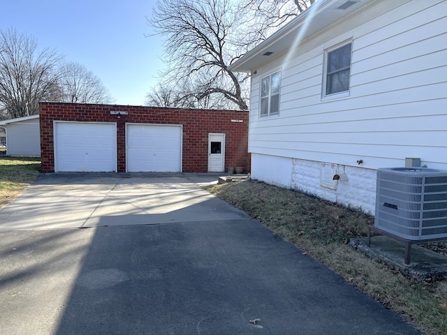 exterior space featuring an outdoor structure, central air condition unit, and a garage