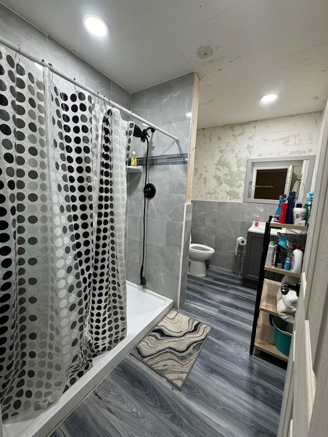 bathroom with a shower with curtain, toilet, tile walls, and wood-type flooring