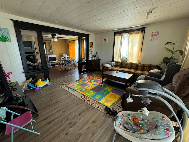 living room featuring ceiling fan and dark hardwood / wood-style flooring