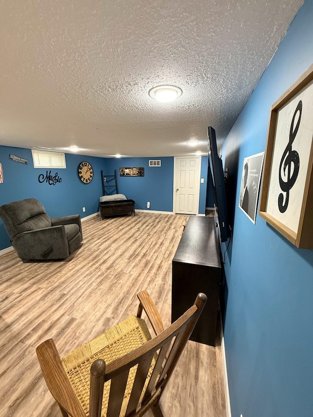 609 E Clark St, La Plata, MO 63549 - game room with wood finished floors, a textured ceiling, and baseboards