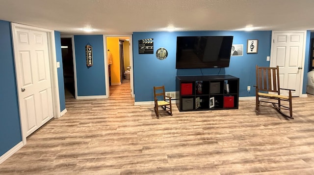 609 E Clark St, La Plata, MO 63549 - living area with wood finished floors, baseboards, and a textured ceiling