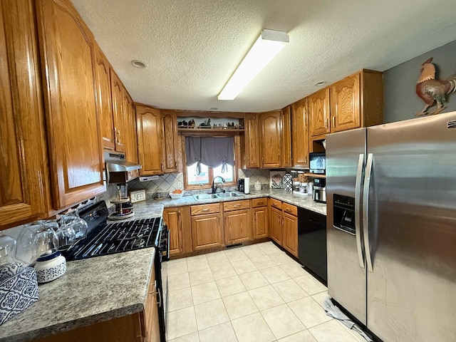 609 E Clark St, La Plata, MO 63549 - kitchen with black appliances, a sink, brown cabinetry, tasteful backsplash, and a textured ceiling