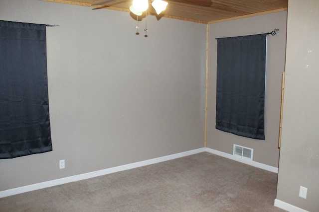 unfurnished room featuring ceiling fan, wooden ceiling, carpet flooring, visible vents, and baseboards