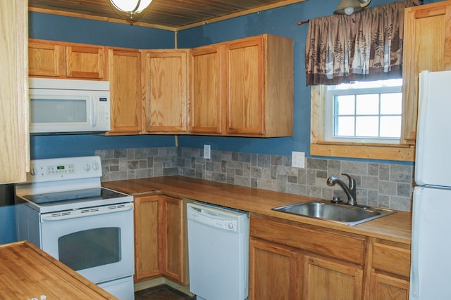 kitchen featuring tasteful backsplash, white appliances, and a sink