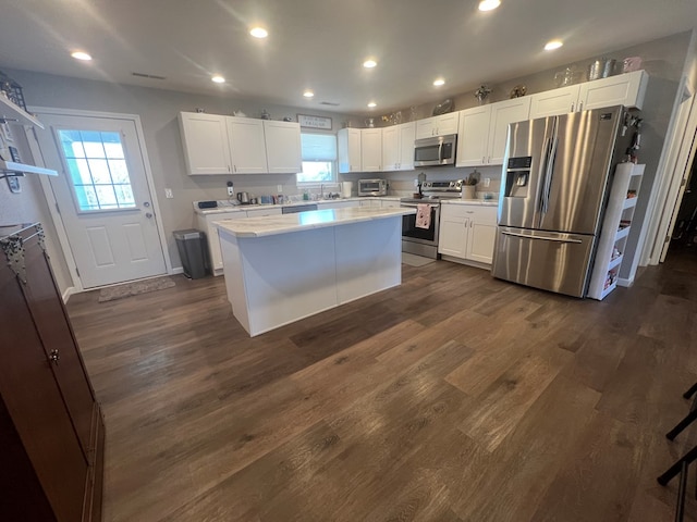 kitchen with white cabinetry, stainless steel appliances, light countertops, and dark wood-type flooring