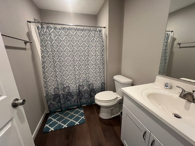 bathroom with toilet, vanity, a shower with shower curtain, and wood finished floors